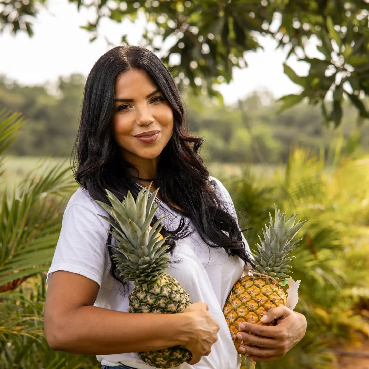 Joven sosteniendo piñas orgánicas cultivadas en Monte Plata. Foto por Morisoñando Restaurante.