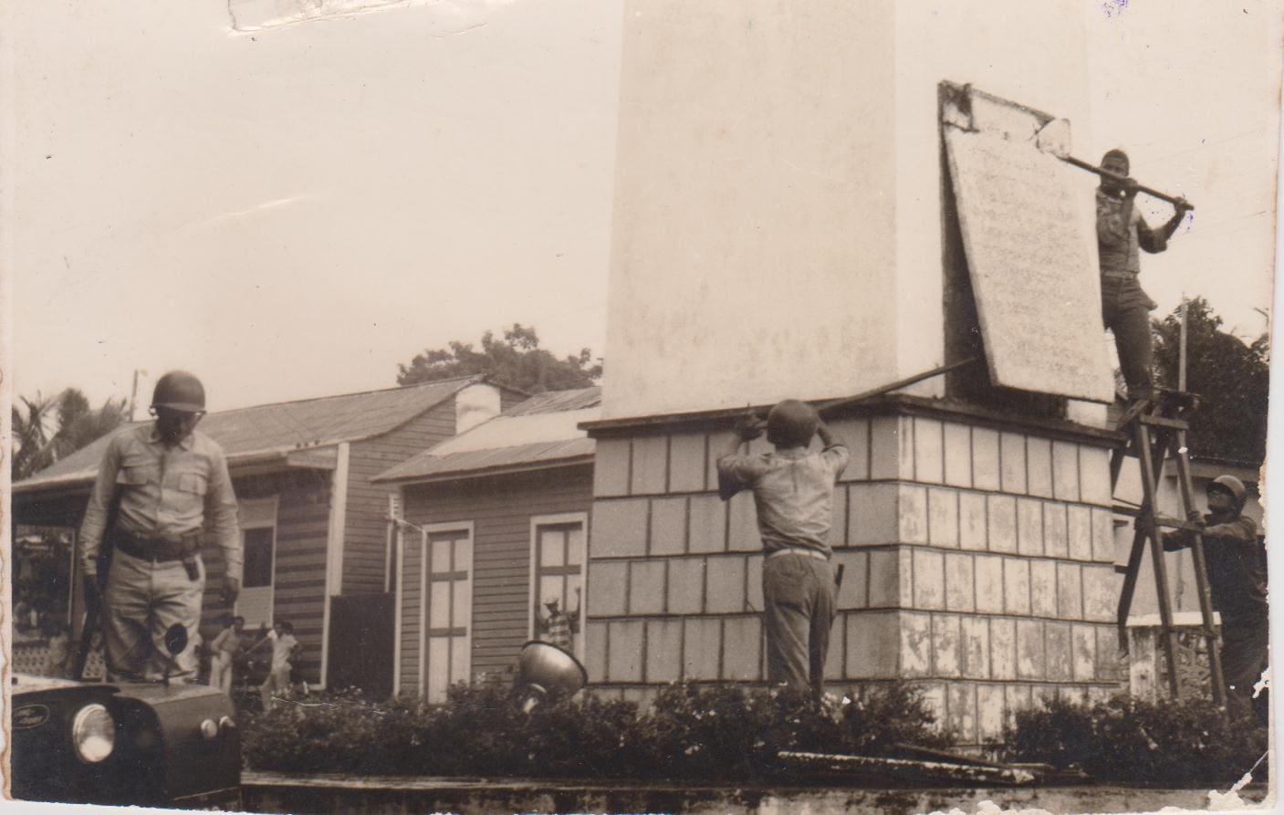 Agentes de la Policía arrancando las placas del Obelisco de La Romana tras la caída de Trujillo. Foto cortesía de Freddy Félix Ysaac