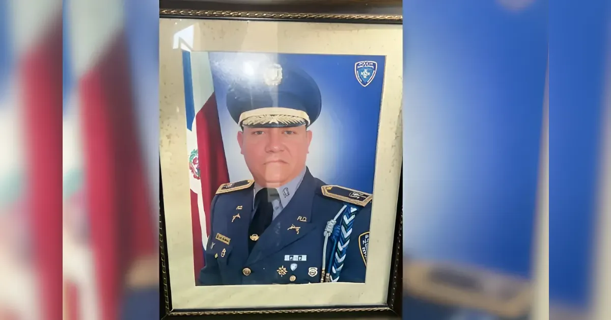 Framed portrait of a uniformed officer with medals, posed in front of a flag.