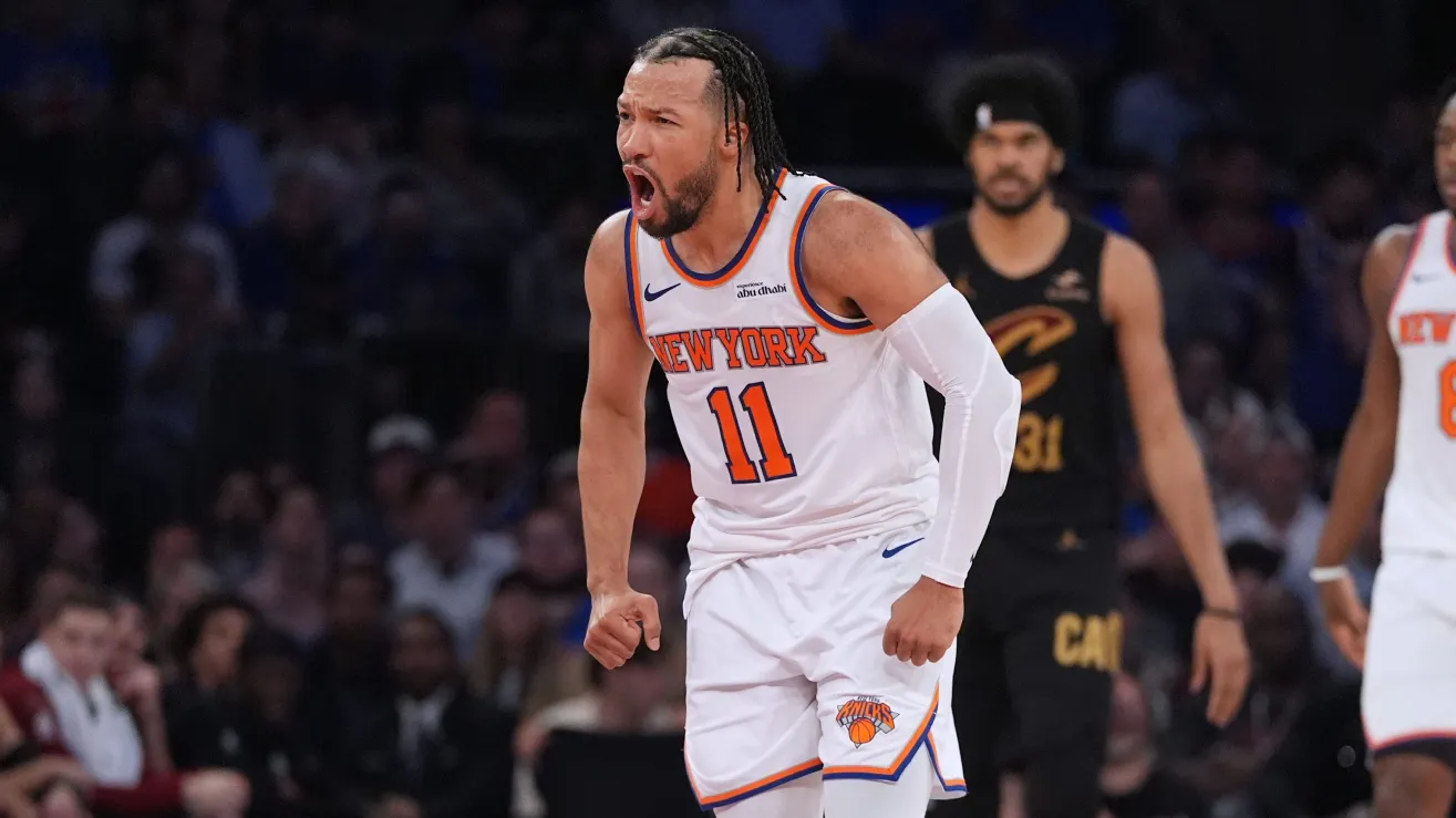 New York Knicks player number 11 shouting with clenched fist on the court during a game, crowd in the background.