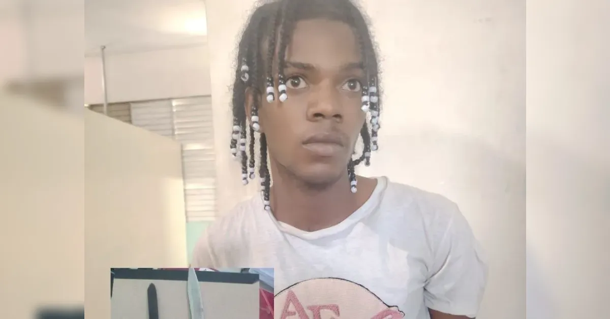 Young person with braided hair and a light gray T‑shirt looks upward in a bright indoor space.