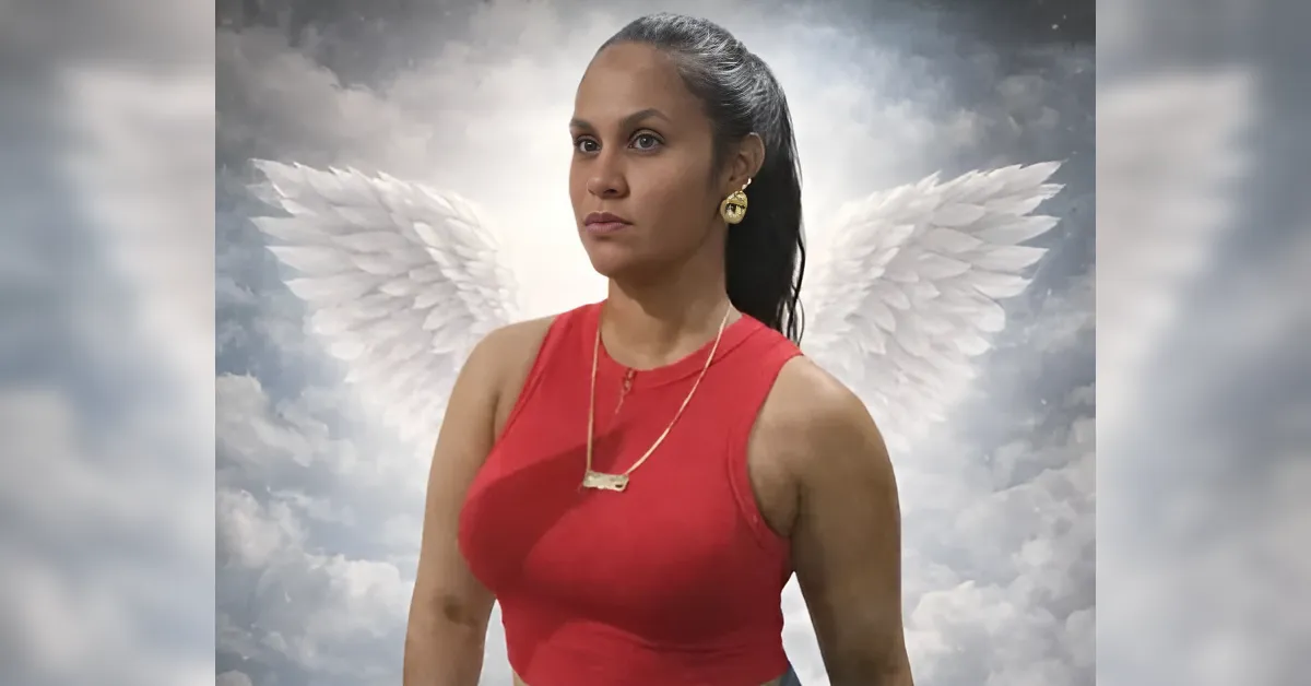 Woman in a red sleeveless top with gold earrings and necklace, standing before a cloudy sky with white angel wings backdrop.