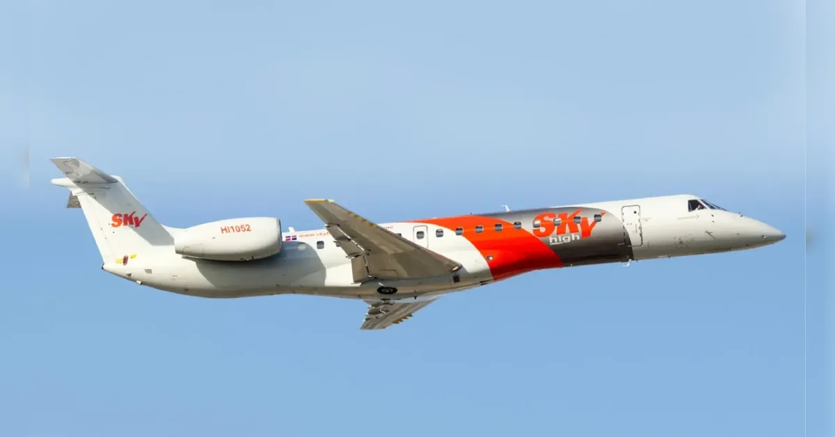 Airliner in flight with white fuselage and red SKY high branding against a blue sky.