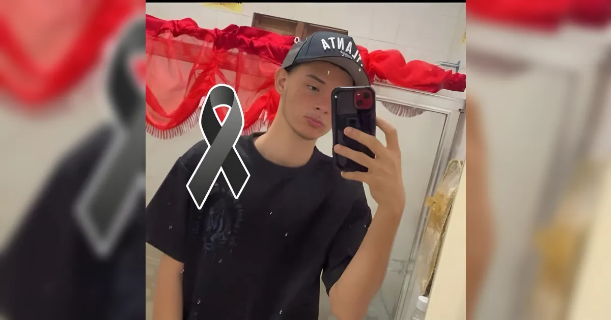 Teenager takes a mirror selfie in a bathroom, wearing a black shirt and cap with a gray awareness ribbon overlay.