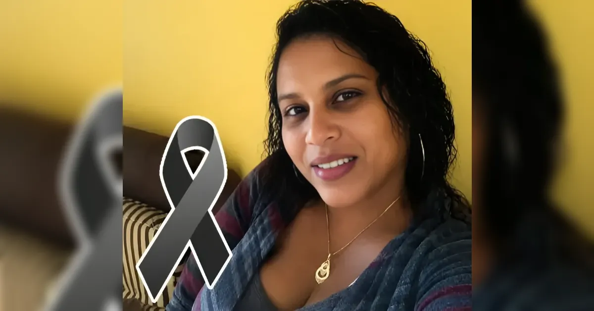 Portrait of a smiling woman with a gray awareness ribbon graphic over the image, standing against a yellow wall.