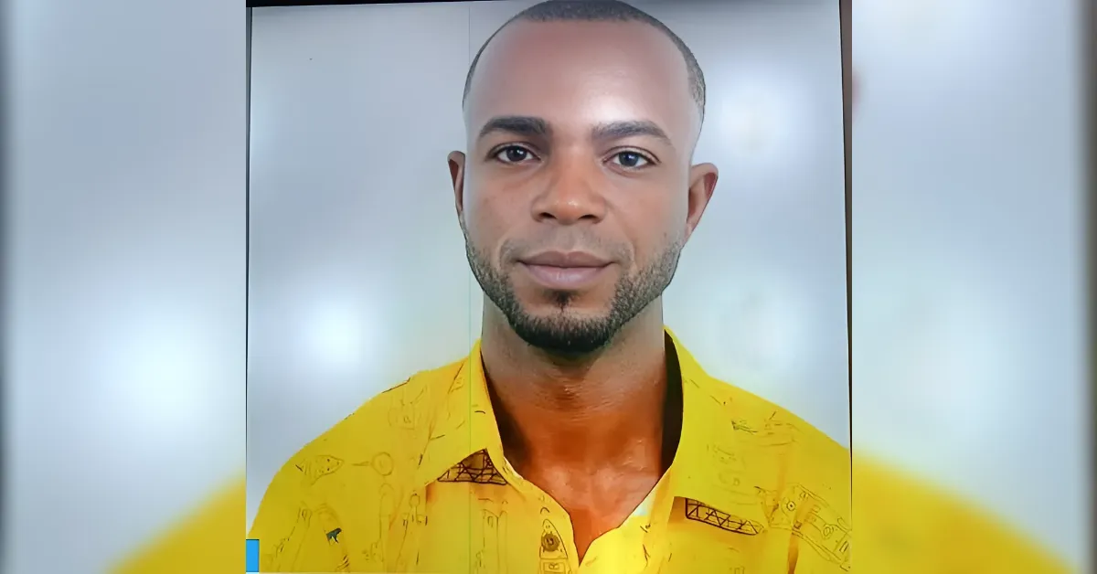 Portrait of a man with short hair and light facial hair wearing a bright yellow shirt, facing the camera.