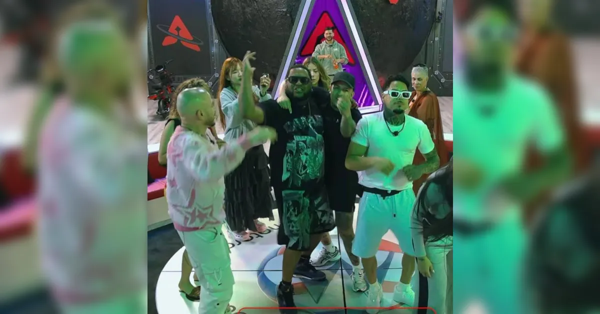 Group of people dancing on a stage with neon lights at a party, camera visible in the background, and a colorful setup behind them in a club scene.