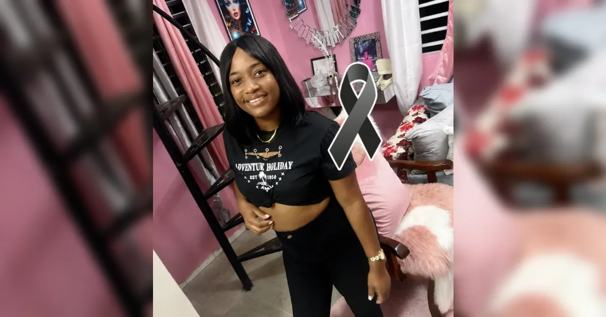 Smiling young woman poses in a pink room with a large gray awareness ribbon indicating support for brain cancer awareness.