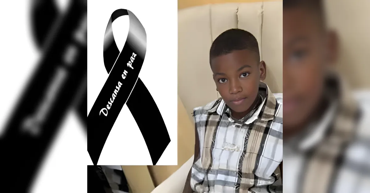 Black 'Descansar en paz' RIP ribbon beside a young boy in a plaid shirt (tribute image).