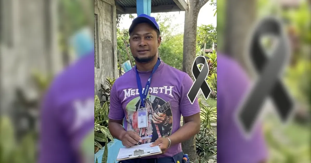 Man in a purple Megadeth shirt and blue cap outdoors, holding a clipboard with an ID lanyard; a black awareness ribbon beside him.
