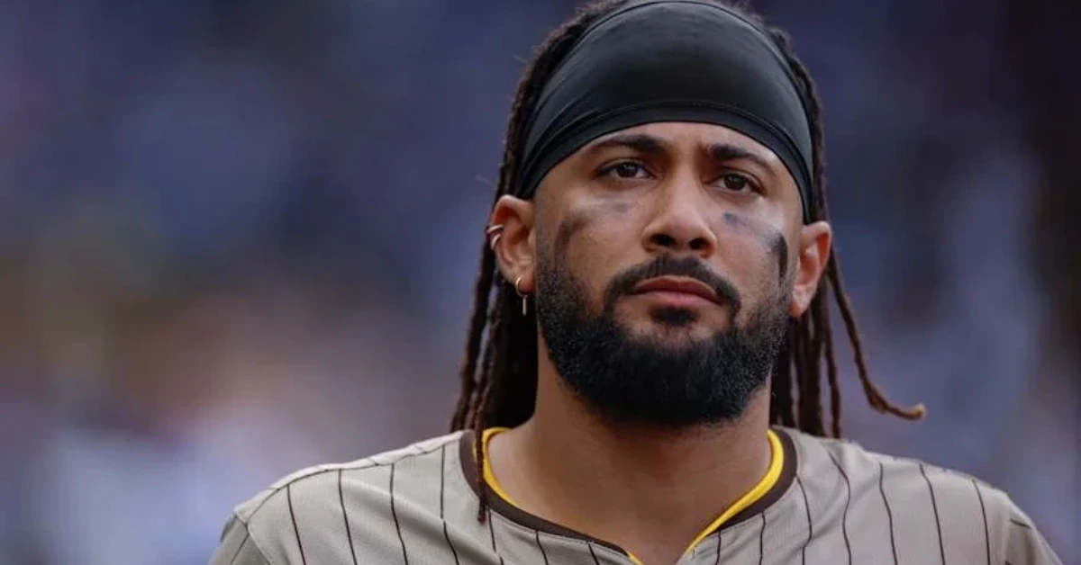 Athlete in a gray pinstripe jersey with a black headband and dirt marks on his cheeks, looking focused ahead.