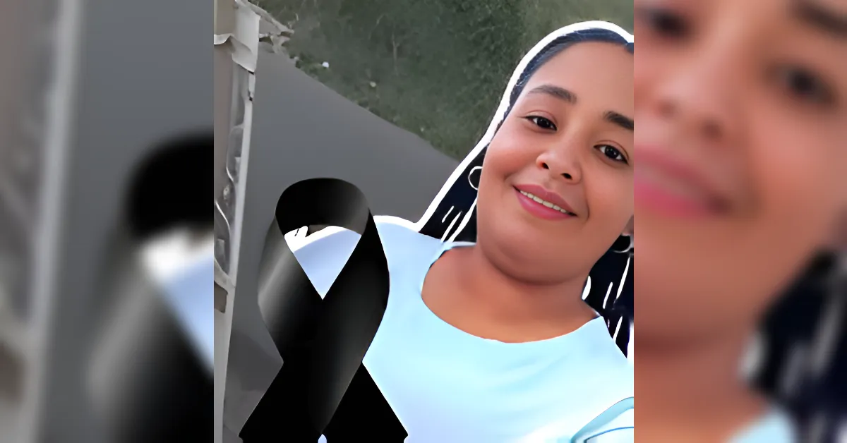 Smiling woman outdoors in a light blue top, with a black awareness ribbon graphic across her torso.