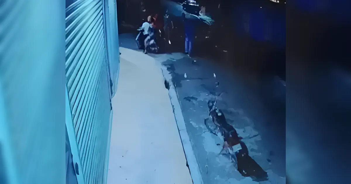 Night alley scene with a blue shutter on the left and a small group of people near a corner ahead.