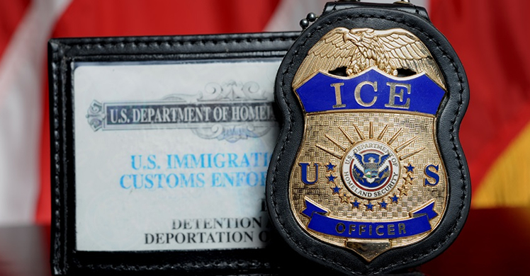 Close-up of an ICE badge with blue and gold detailing beside a display card for U.S. Immigration and Customs Enforcement.