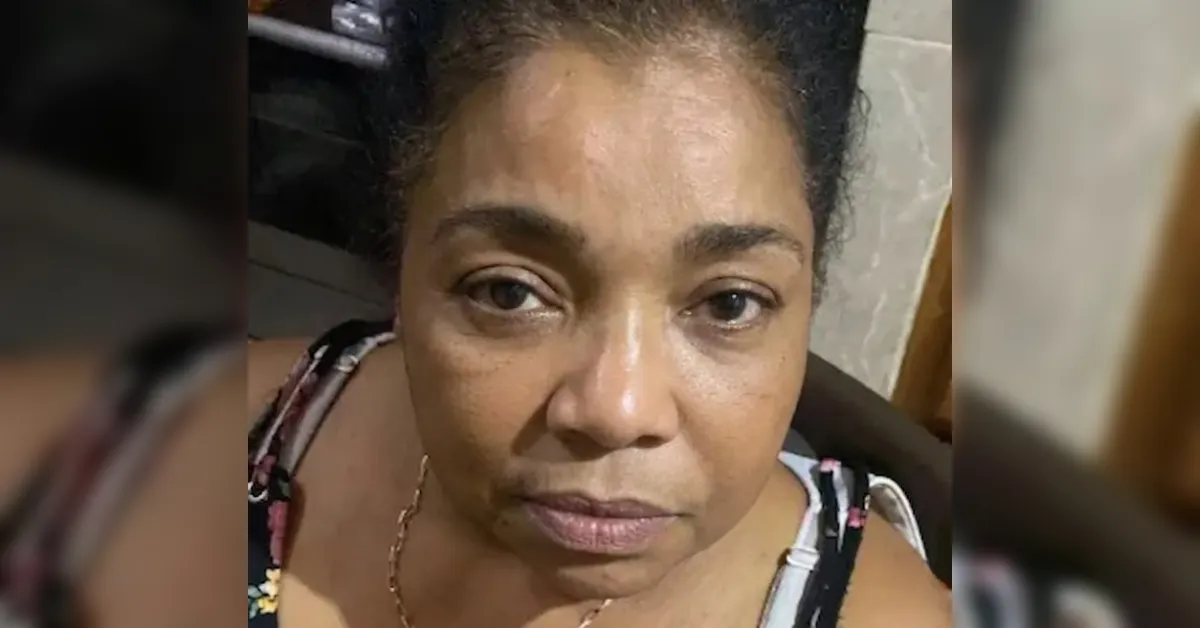Close-up portrait of a woman looking at the camera with a neutral expression indoors.