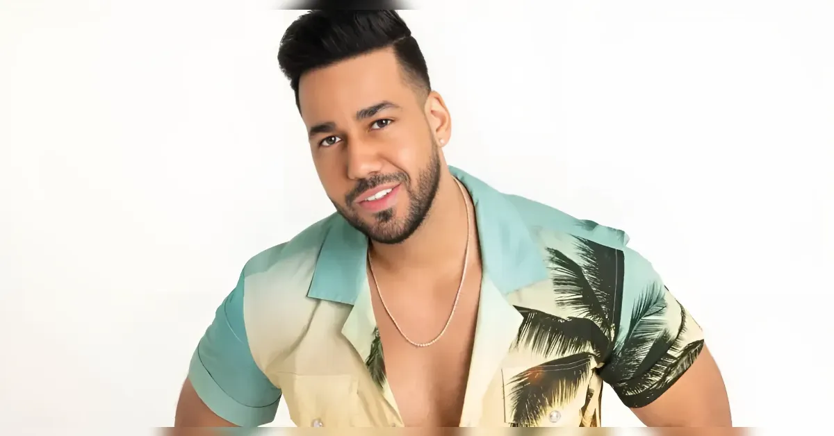 Smiling man in a tropicalprint short-sleeve shirt posing in a studio.
