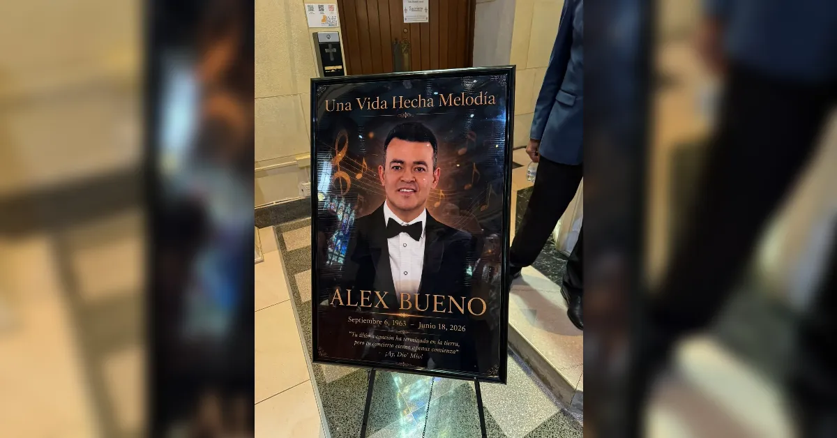 Memorial poster on a stand featuring a portrait of Alex Bueno in a tuxedo, with the title 'Una Vida Hecha Melodía' and dates Septiembre 6, 1963 – Junio 18, 2026.