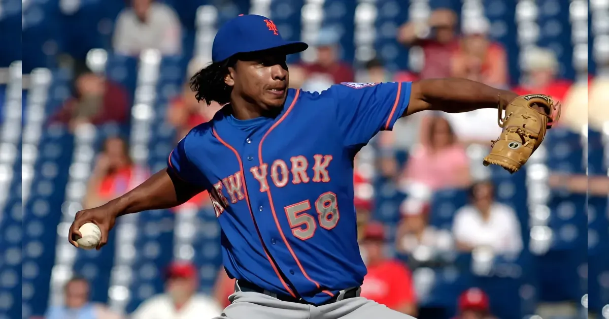 Pitcher in a blue New York Mets uniform delivering a pitch with the ball in his left hand and a glove on his right hand.