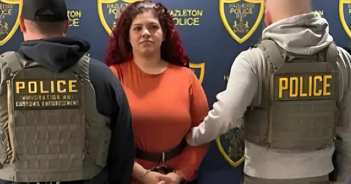 Woman in orange shirt stands between two officers in tactical vests labeled POLICE during a police briefing.