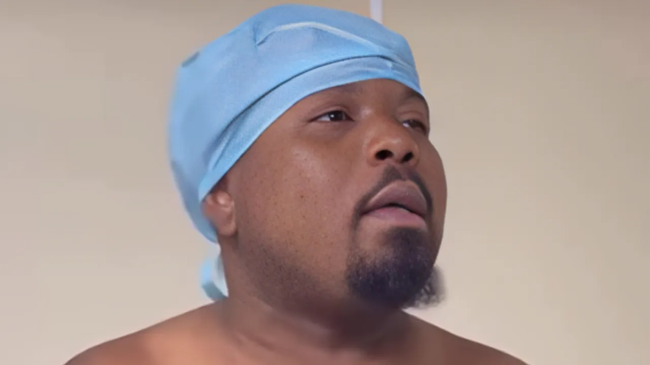 Man wearing a light blue surgical cap, looking upward in a close-up portrait