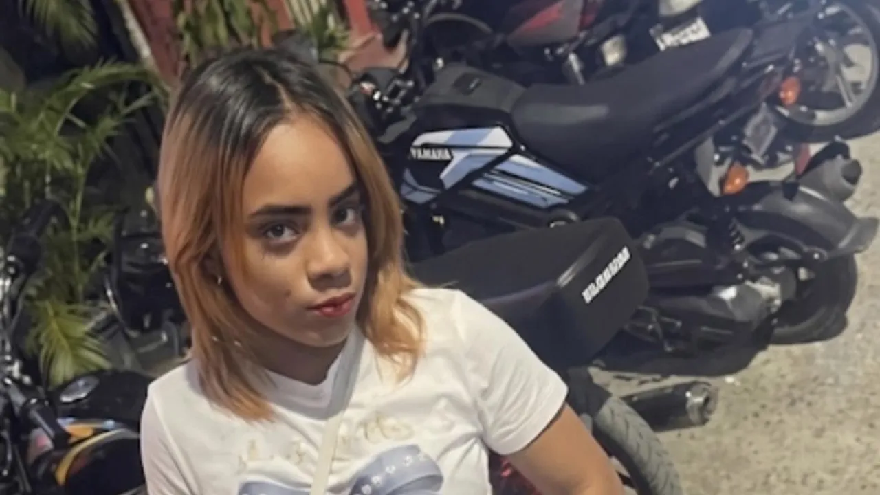 Young woman with shoulder-length blonde hair posing in front of parked motorcycles. Describes the scene and subject clearly and concisely.