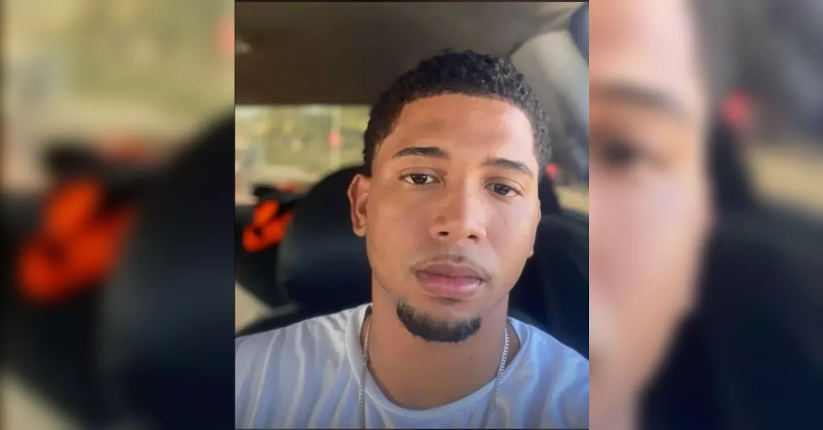 Selfie of a man with short curls and a goatee in a car, looking at the camera.
