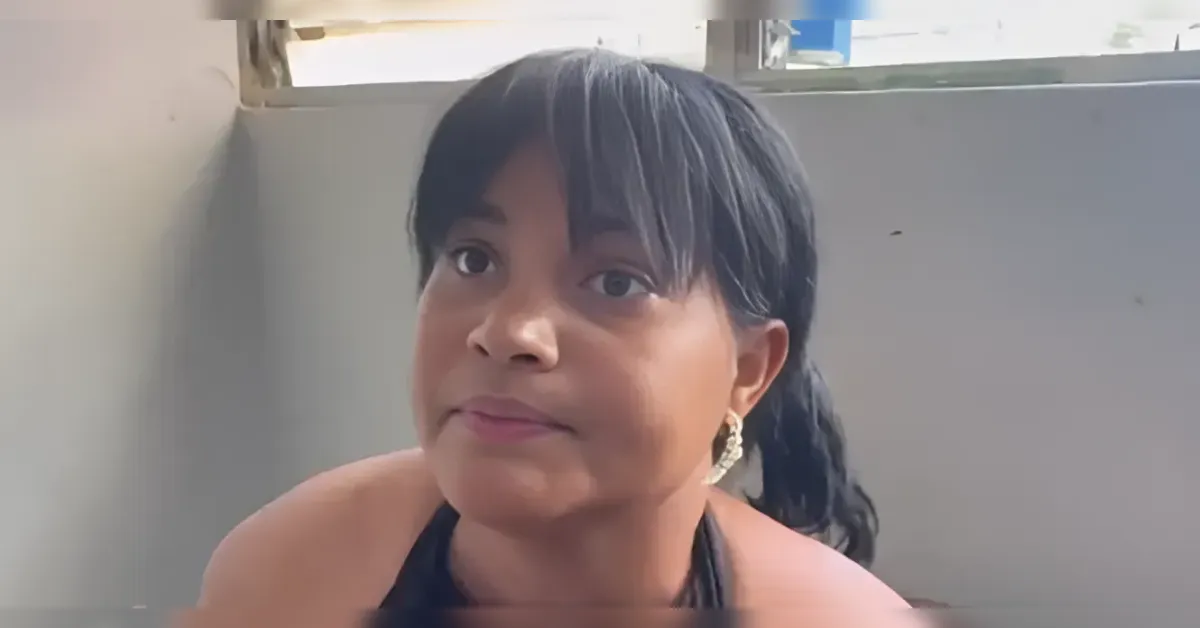 Close-up of a young girl with dark hair looking at the camera indoors.