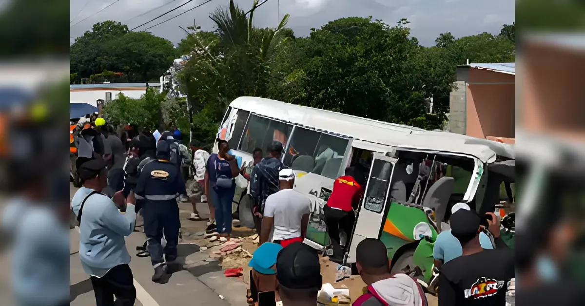 Overturned bus on a street with a crowd gathered around, some people appearing to assist or inspect the scene.