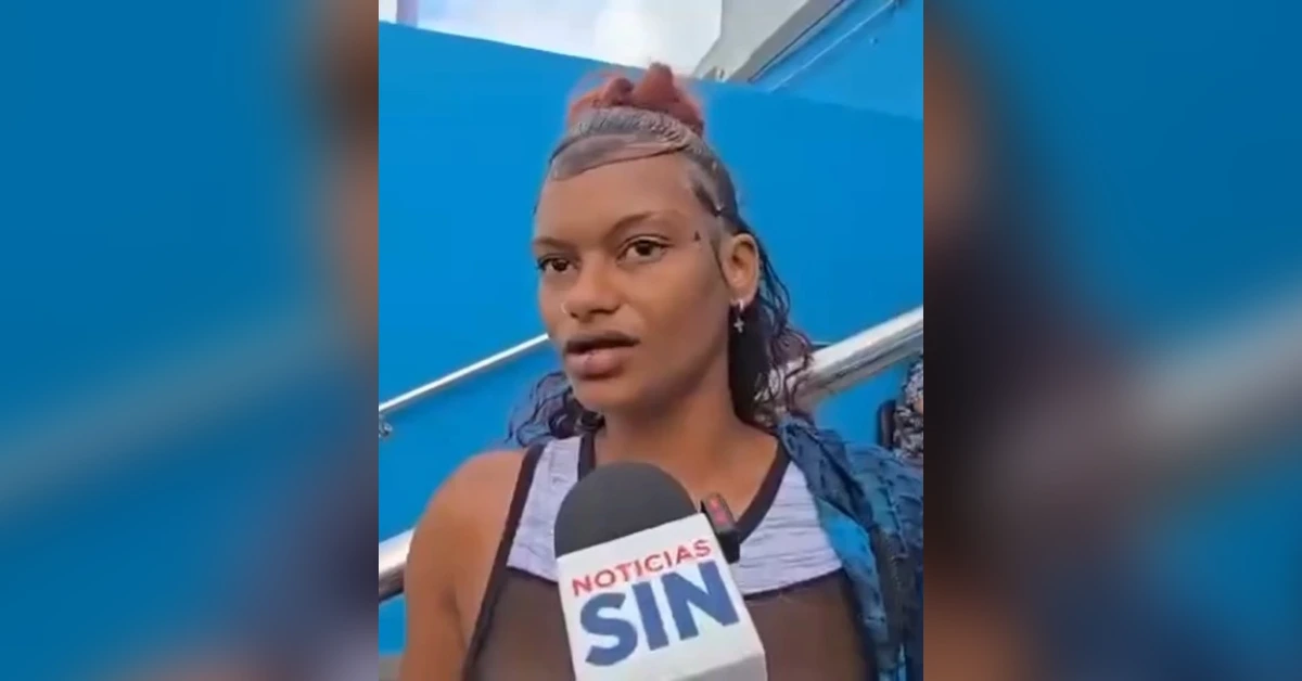 Young woman giving an on-camera interview with a Noticias Sin microphone, against a blue background.