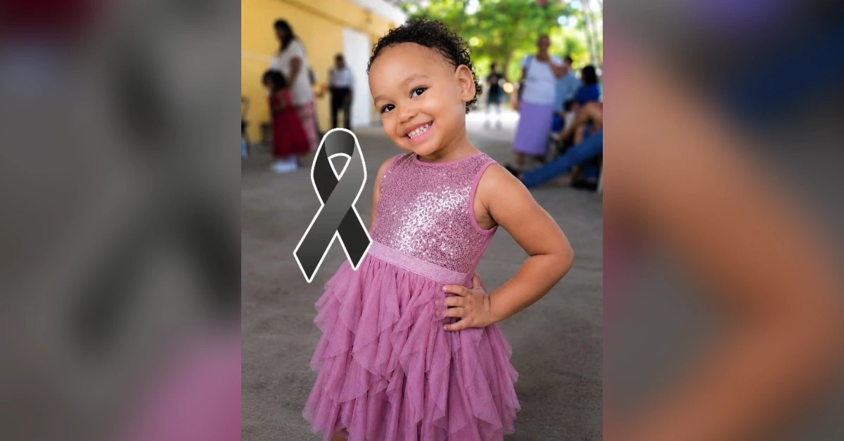 Smiling girl in a pink sparkly dress at an outdoor event, with a large black awareness ribbon overlay.