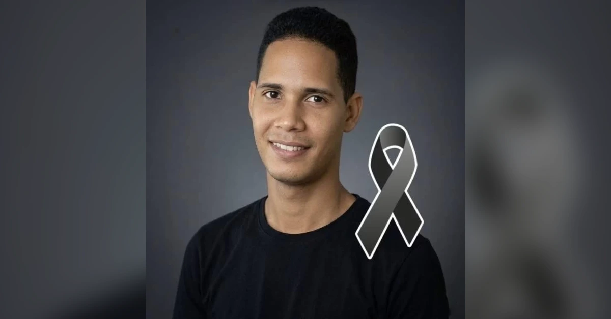Smiling man in a black shirt with a gray awareness ribbon overlay, symbolizing brain cancer awareness.