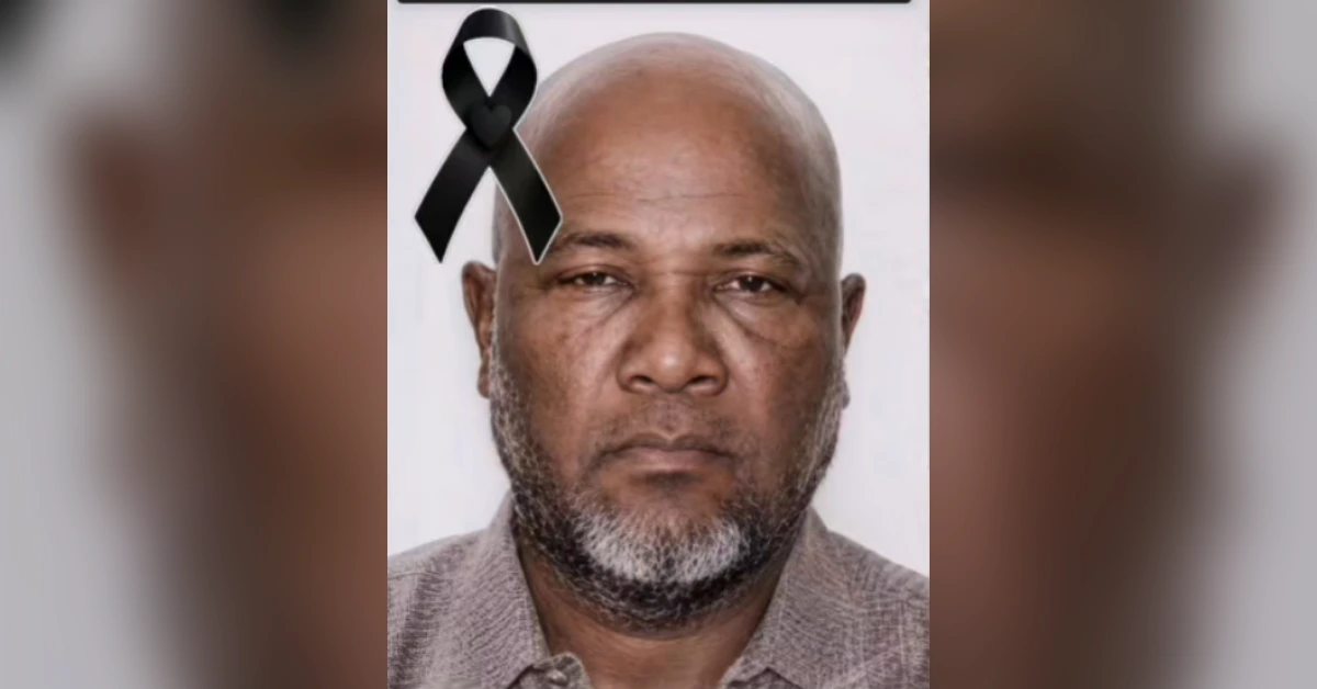 Portrait of a middle-aged man with a gray beard, neutral expression, and a black mourning ribbon in the top-left corner.