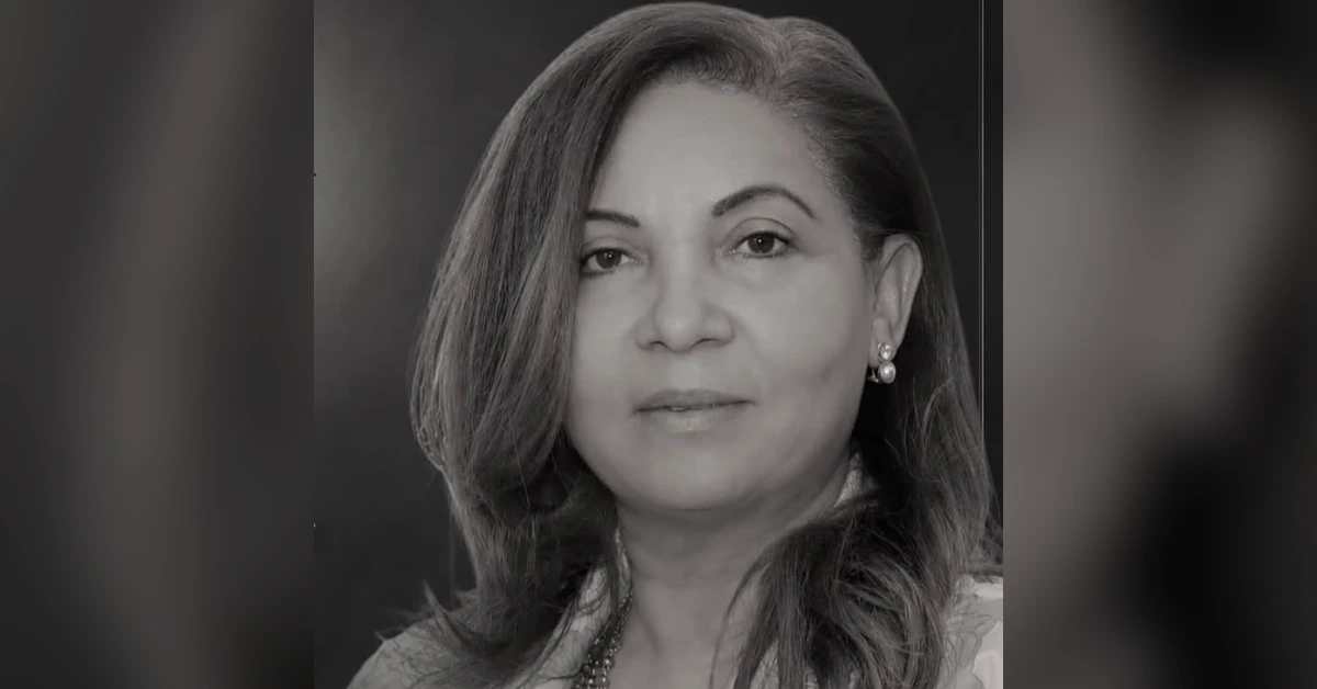 Black-and-white head-and-shoulders portrait of a woman with shoulder-length hair and pearl earrings, facing forward.