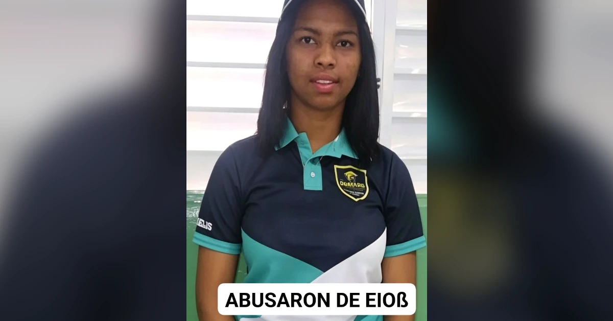 Young woman in a navy polo shirt with teal accents stands indoors, a white caption bar at the bottom showing Spanish text about abuse.