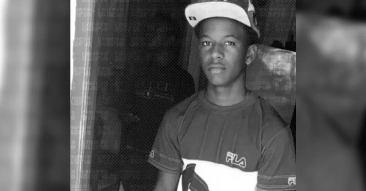 Young man wearing a white cap and FILA shirt, looking at the camera in a casual portrait image.