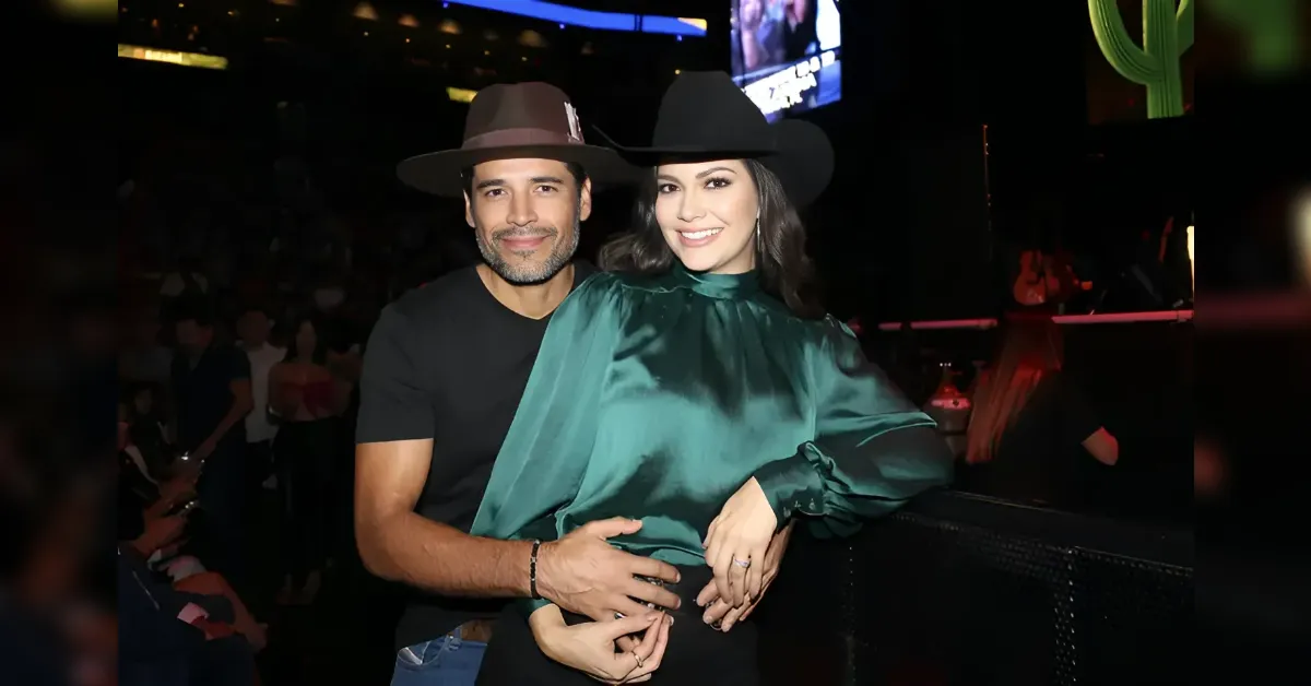 Couple wearing cowboy hats posing together at a concert, man in a black t-shirt and the woman in a green satin blouse.