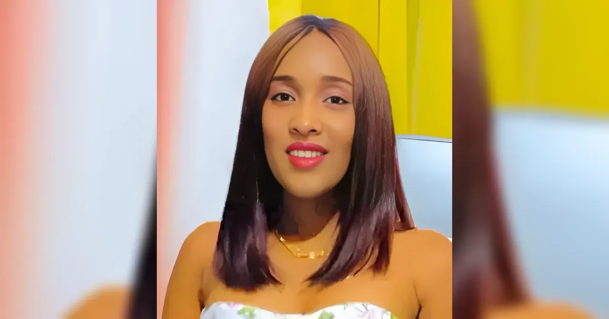 Portrait of a smiling woman with shoulder-length hair wearing a white floral top, against a bright yellow background.