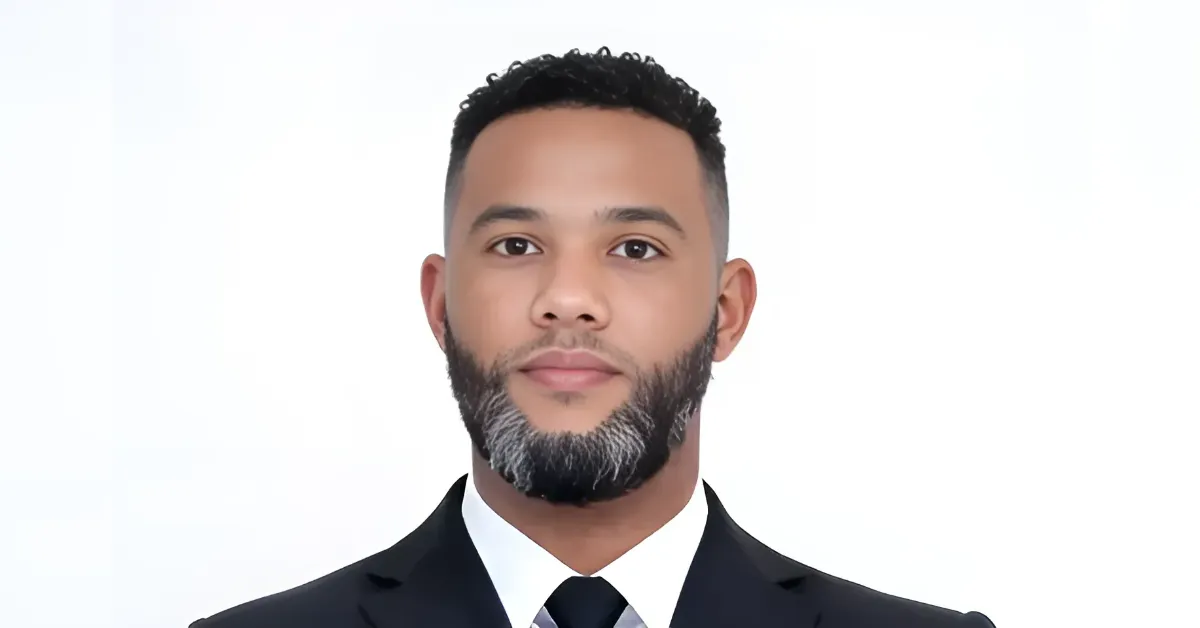 Professional head-and-shoulders portrait of a man in a black suit and white shirt against a white background.
