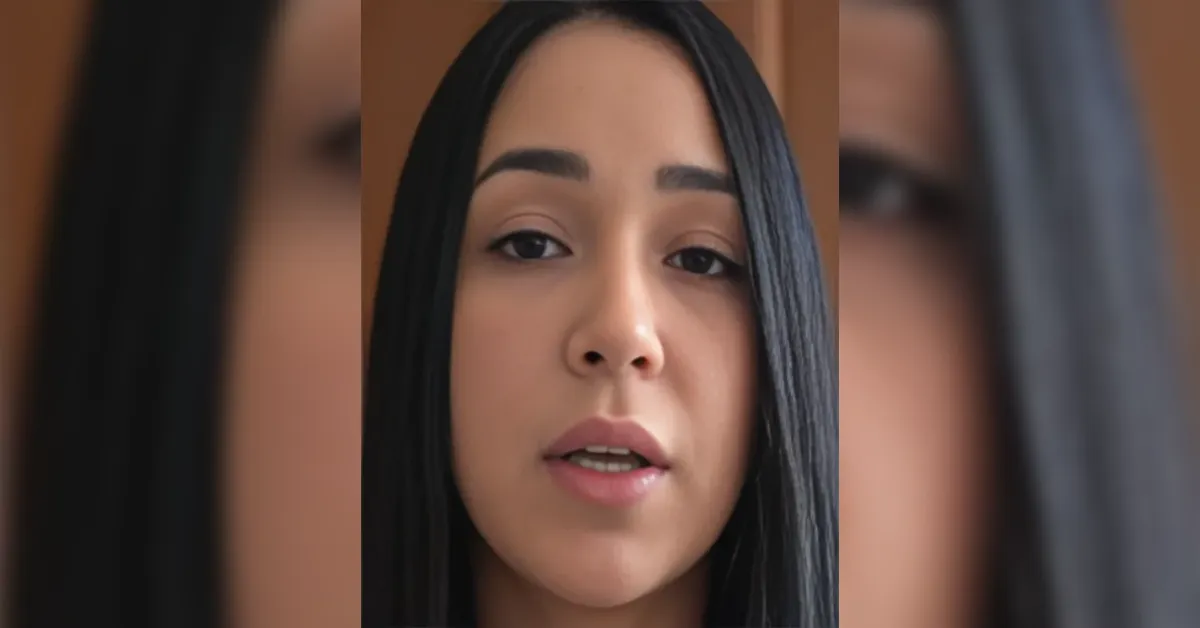 Close-up of a young woman with long black hair speaking to the camera.