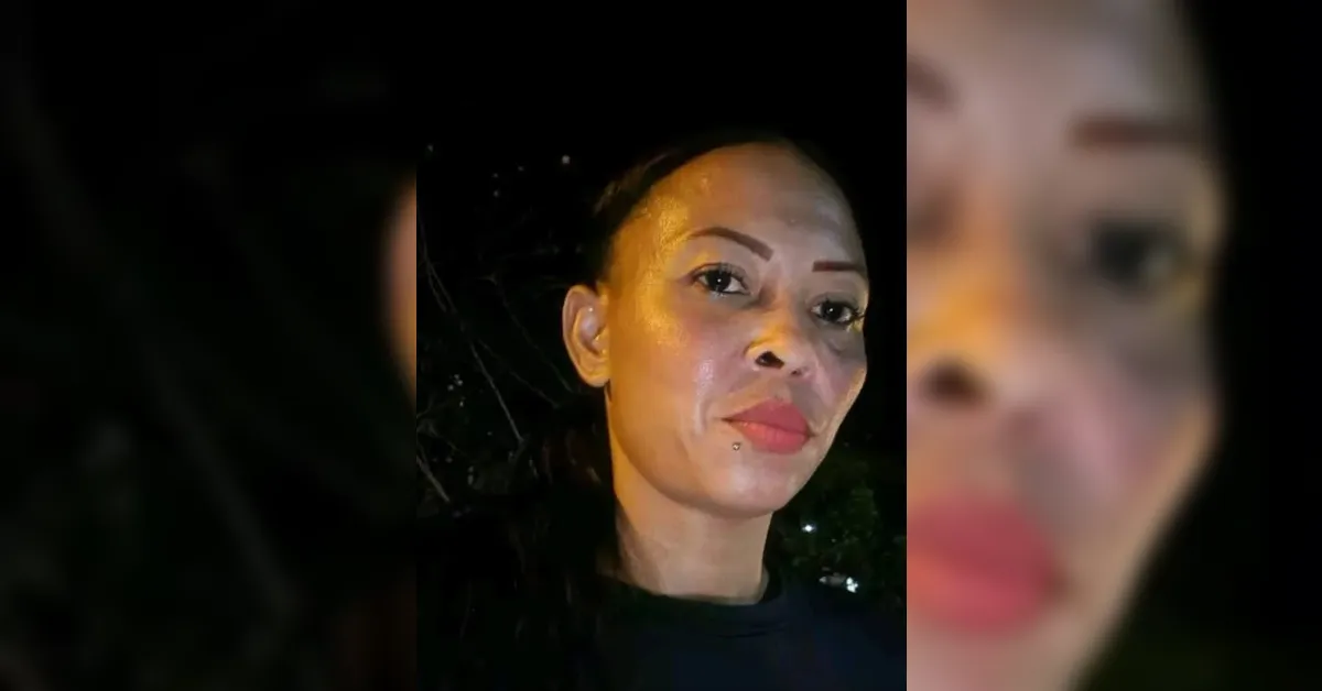 Close-up portrait of a woman with glossy makeup and bold eyebrows at night, looking at the camera outside the frame.