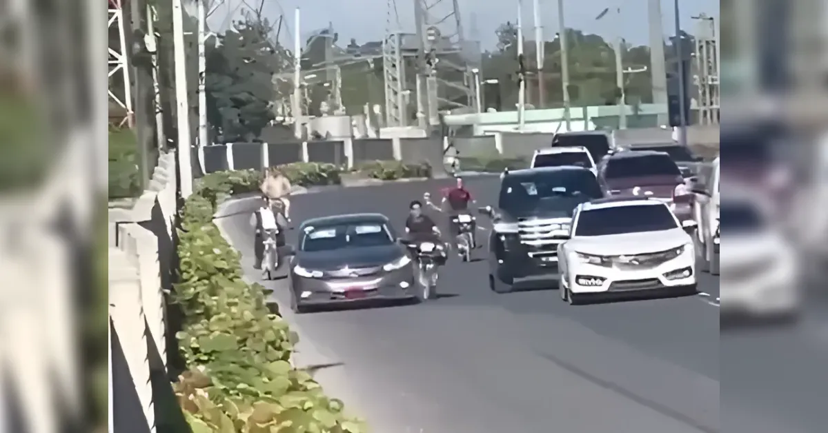 Busy urban street with cars and multiple motorcycles moving in both directions.