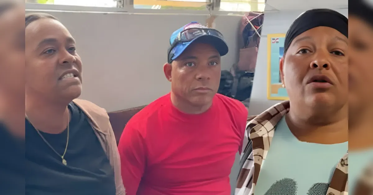Three people sit close together in a casual indoor waiting area, looking toward the camera with neutral or curious expressions.
