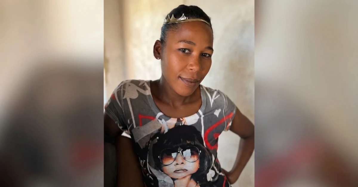 Young girl posing with a small crown headband, wearing a gray graphic tee featuring a large portrait of a woman in sunglasses.