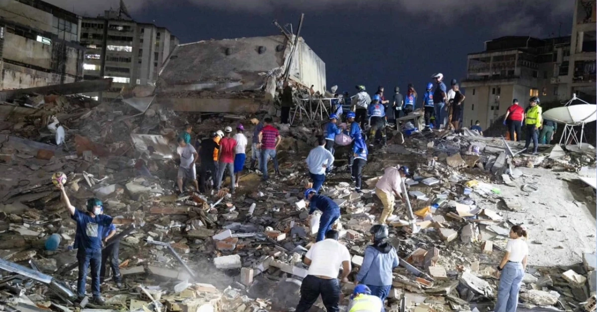 Crowd of volunteers digging through rubble at night after a building collapse, helping in a disaster response scenario.