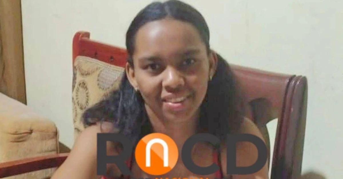 Smiling woman seated indoors at a table, with a large watermark across the image.