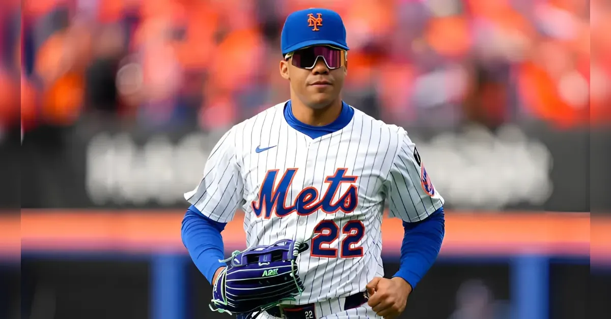 Baseball player in a Mets pinstripe uniform with the number 22, wearing a blue cap and sunglasses, glove in hand on the field