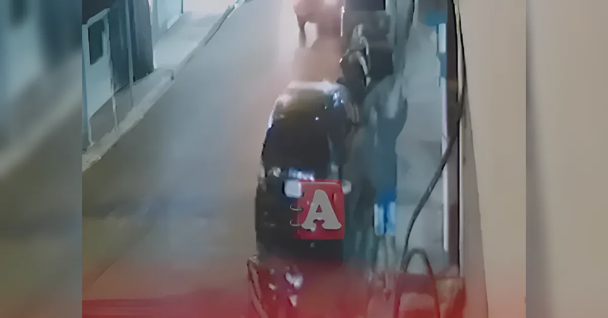 Nighttime street scene from a security camera showing a dark car parked along the curb and a person nearby in the background.