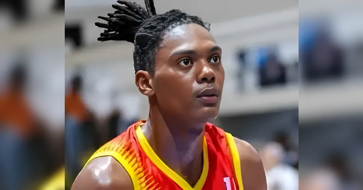 Basketball player with braided hair in a red and yellow jersey, looking upward in a gym.**Note: The text after double asterisks is not needed; remove in final output**