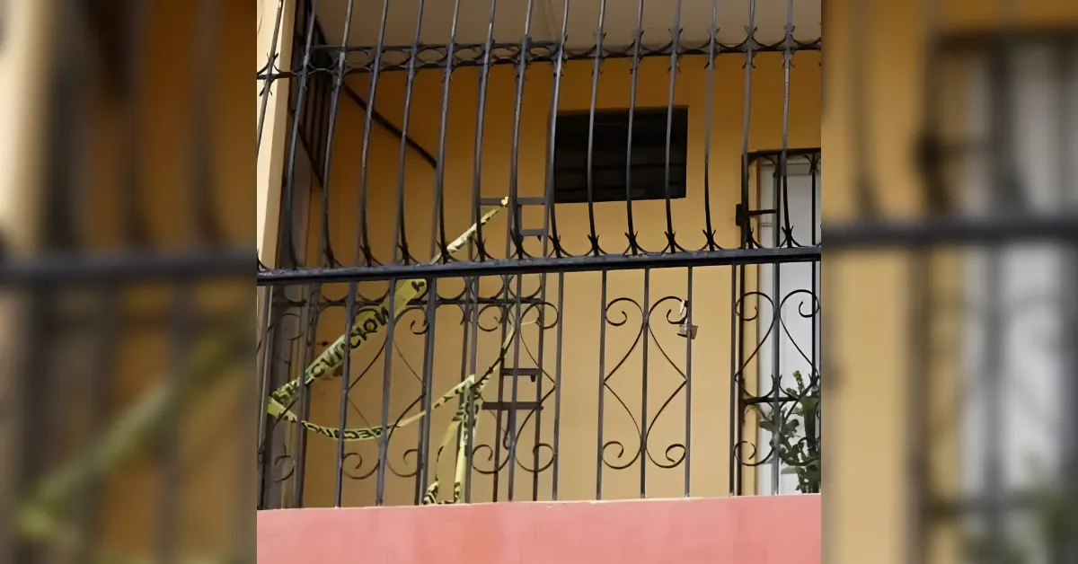 Balcony or window with decorative iron bars and yellow caution tape stretched across, suggesting a restricted area or incident outside a building.
