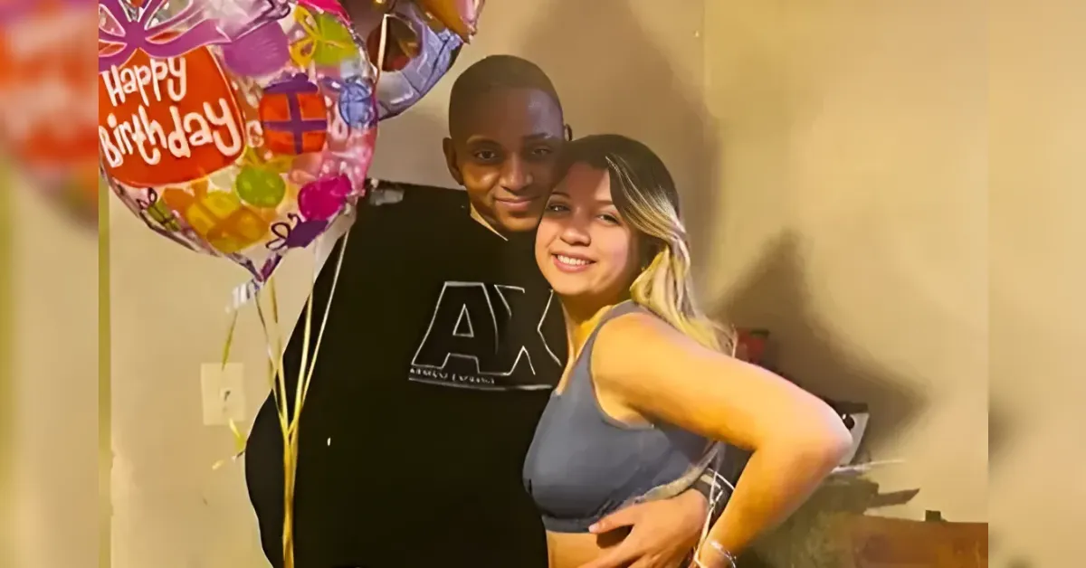 Smiling couple posing indoors with colorful birthday balloons in the background
